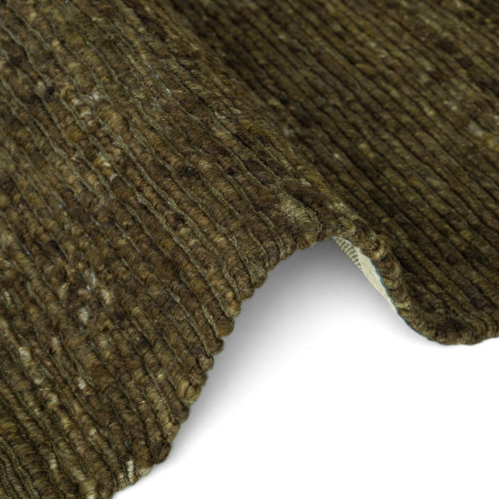Close-up of a textured brown carpet corner on a white background