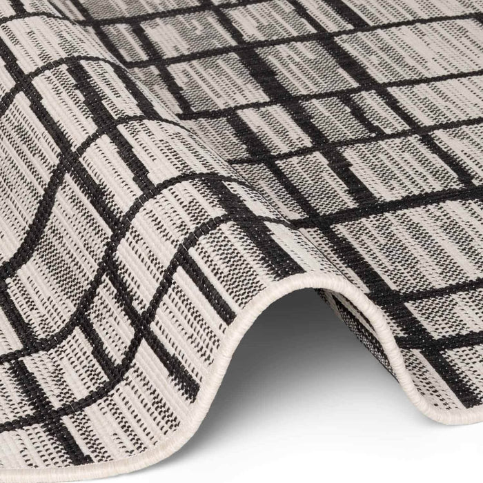 Close-up of a black and white checkered rug on a white background