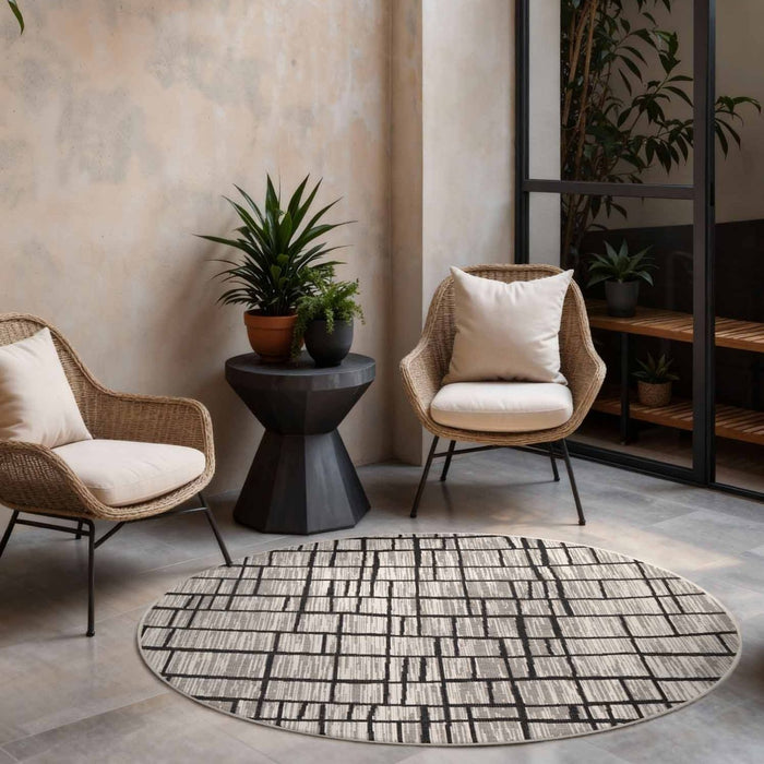 Modern living room with wicker chairs, a round rug, and decorative plants.
