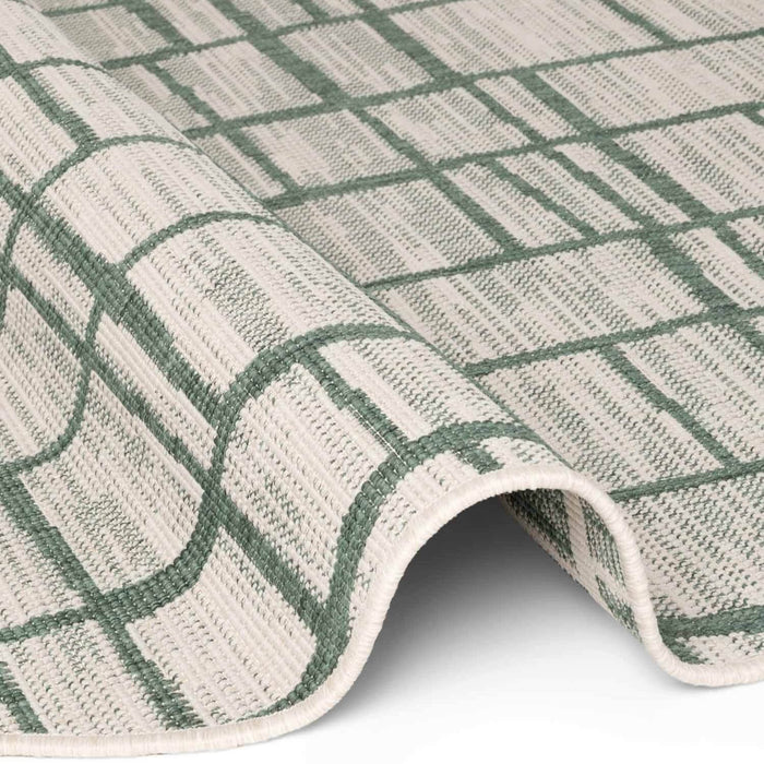 Close-up of a green and beige checkered rug on a white background