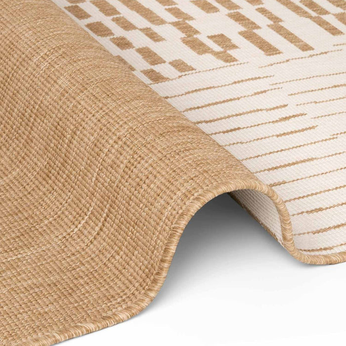 Close-up of a beige and white patterned rug corner