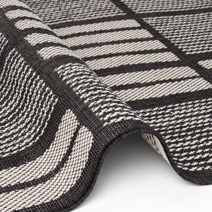 Close-up of a black and white striped rug with geometric pattern
