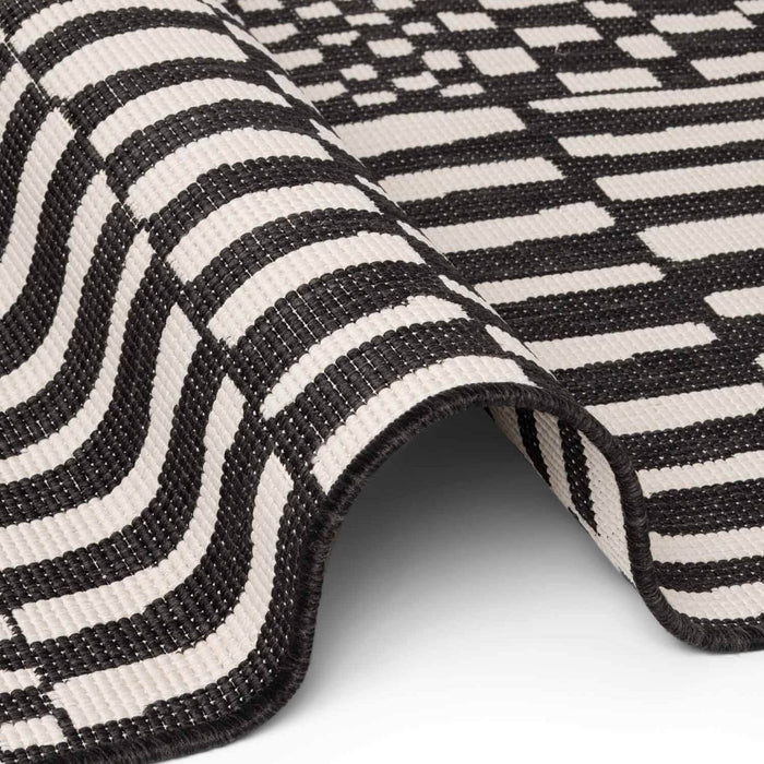 Close-up of a black and white striped rug on a light gray background