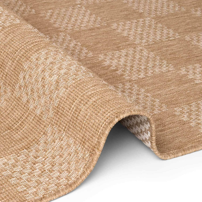 Close-up of a textured beige rug with a subtle pattern on a white background