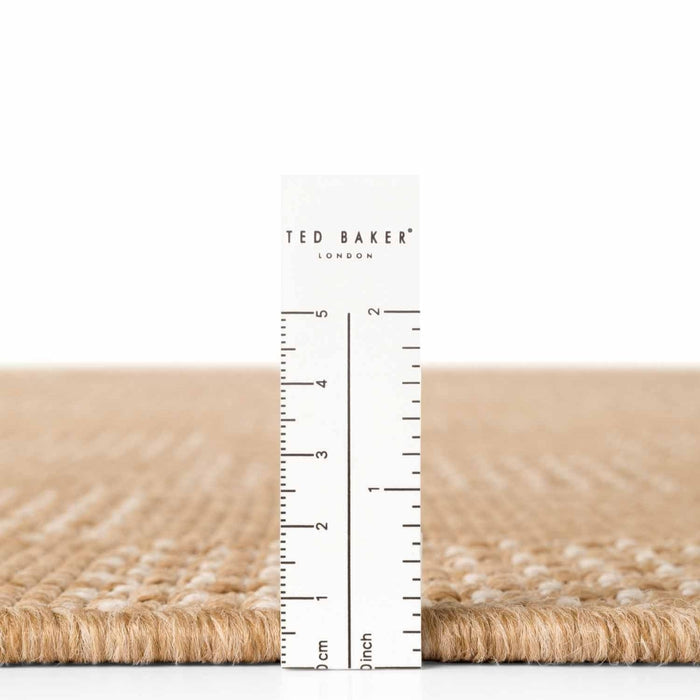 Close-up of a textured surface with a ruler and 'Ted Baker' branding.