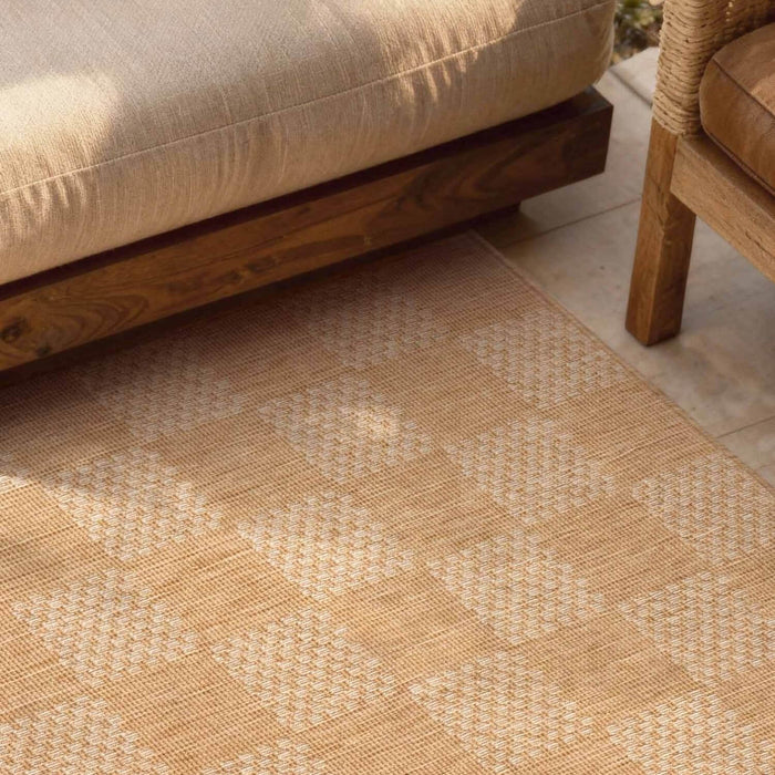 Patterned beige rug on a patio with wooden furniture