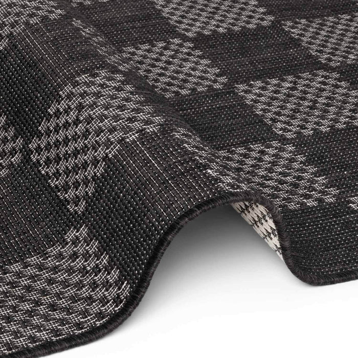 Close-up of a textured black and gray checkered fabric with a white background
