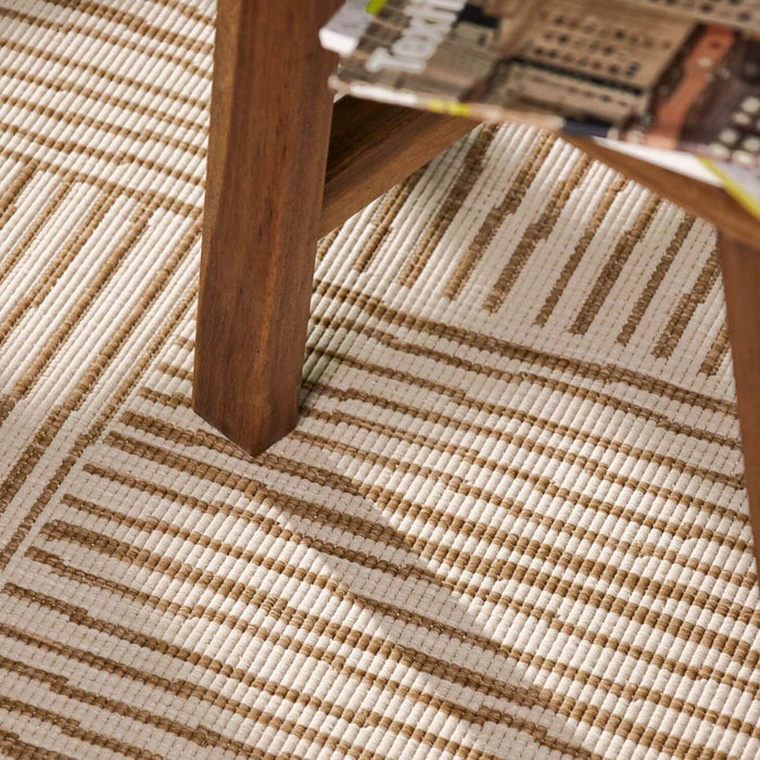 Close-up of a wooden table leg on a textured beige and brown rug.