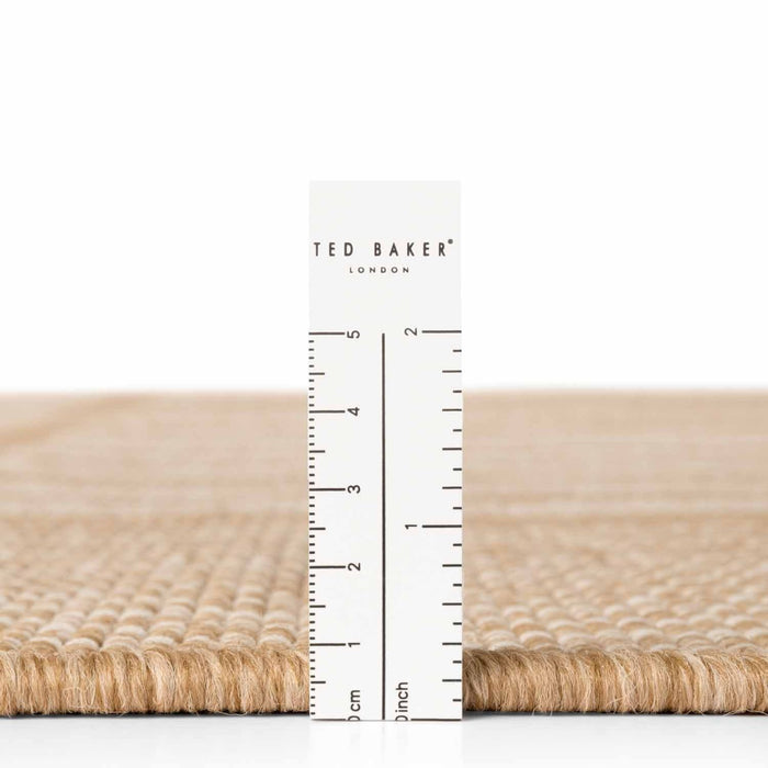 Beige woven mat with a ruler and 'Ted Baker' branding on a white background