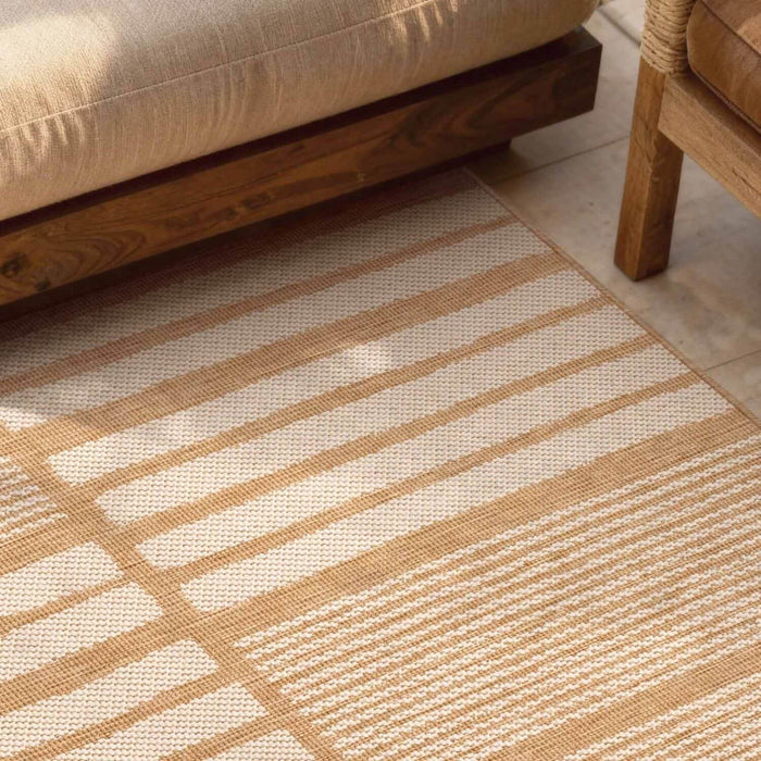 Close-up of a beige and white striped rug with wooden furniture in the background