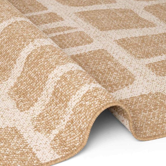 Close-up of a beige and white patterned rug on a plain background
