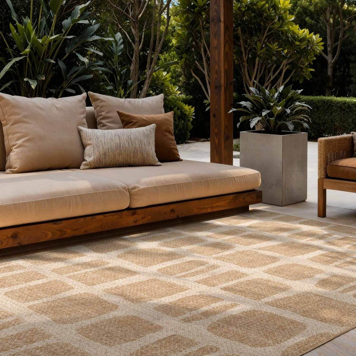 Outdoor patio with beige sofa, patterned rug, and potted plants