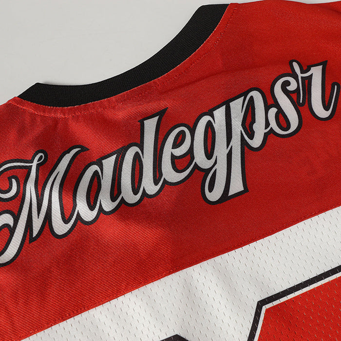 Red varsity football jersey with black collar, white mesh panel, and bold scripted Madegast lettering across the back