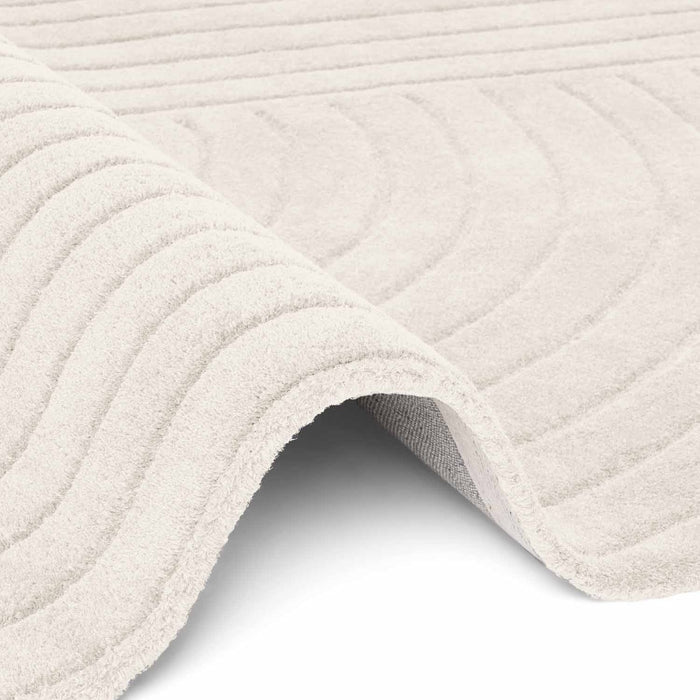 Close-up of a textured beige bath mat on a white background