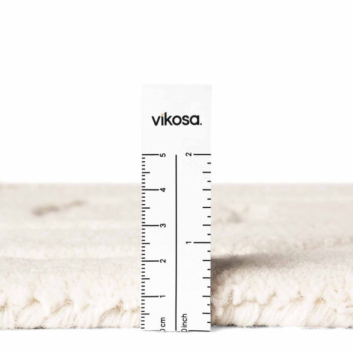 Close-up of a white marble surface with a ruler and 'vikosa' branding.