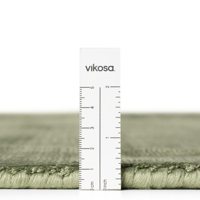 Green rug with a ruler and 'vikosa' branding on a white background