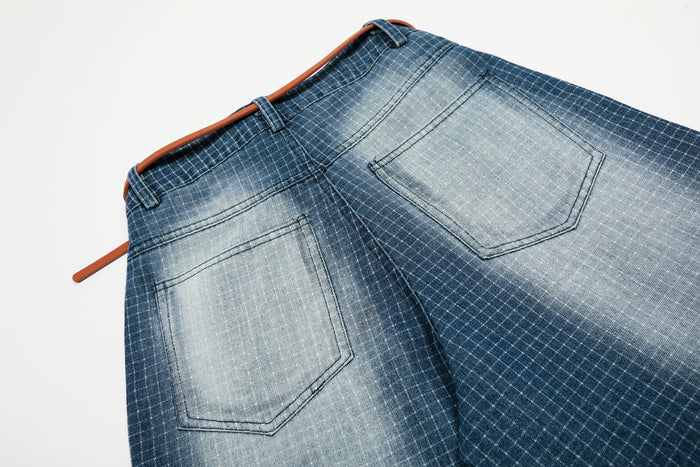 Back pocket close-up on washed blue grid denim shorts with orange belt
