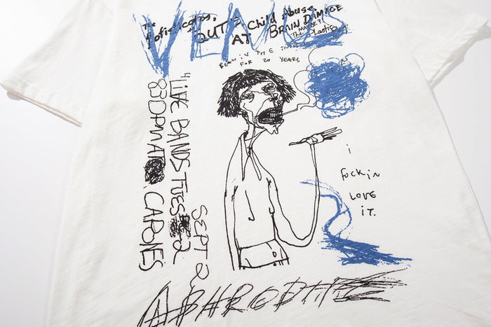 White graphic T-shirt with abstract hand-drawn figure, blue and black sketch lettering, and edgy streetwear artwork