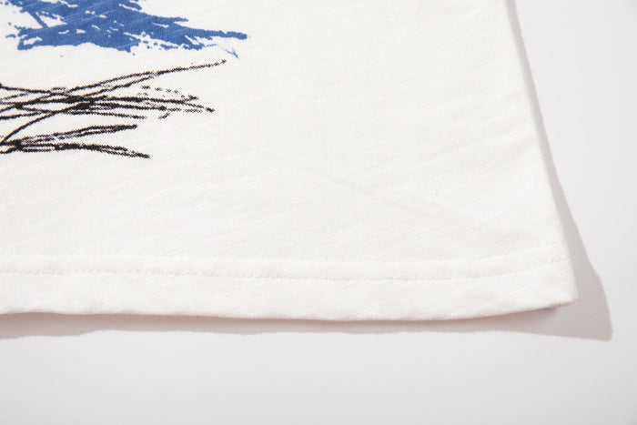 White graphic T-shirt hem with abstract blue and black sketch print on soft cotton fabric