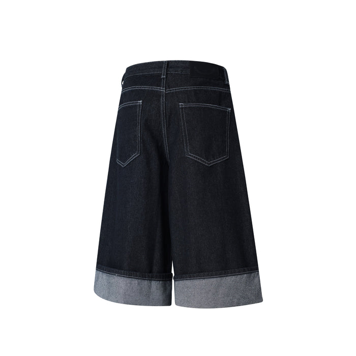 Back view of dark wash wide-leg denim shorts with two patch pockets and light hem cuffs