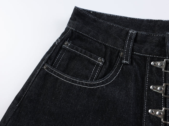 Close-up of the front left pocket and waistband on dark wash denim shorts