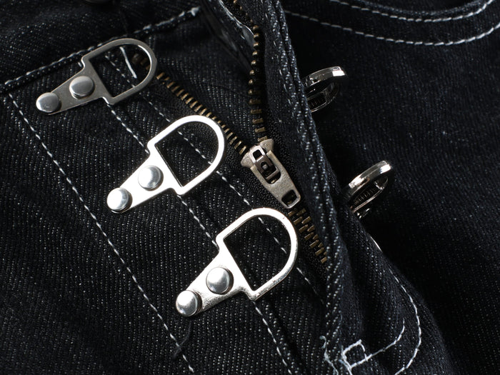 Close-up of the front buckle hardware and zipper area on dark wash denim shorts