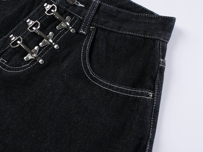 Front upper section of dark wash denim shorts showing buckle closures and right pocket
