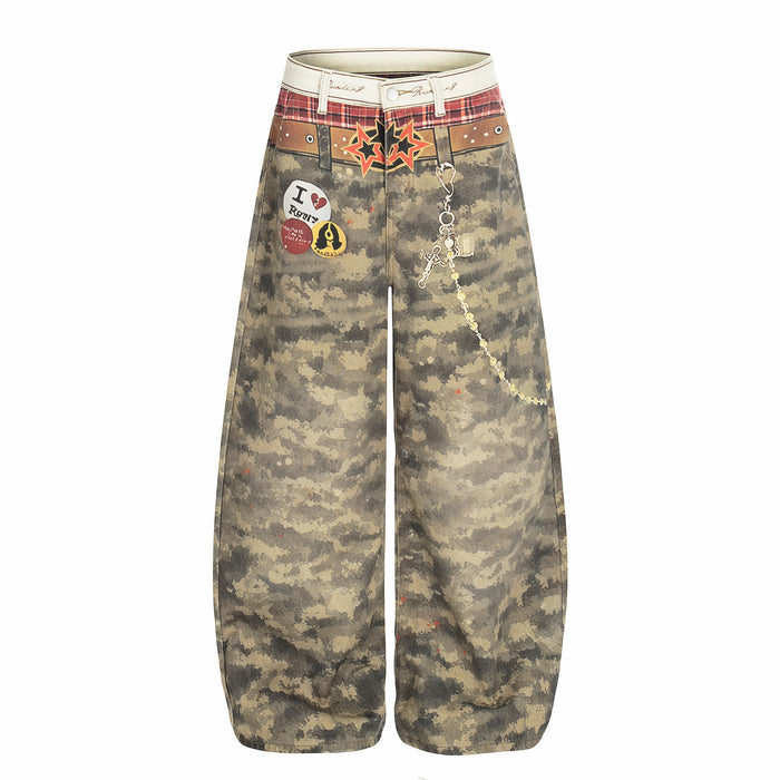 Front view of wide-leg camo patchwork denim pants with plaid waistband and chain detail