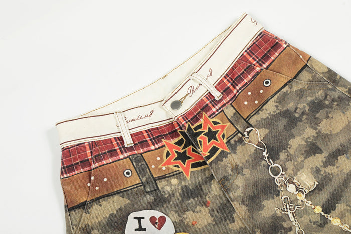 Close-up of waistband on camo patchwork denim pants with plaid trim, button, and belt loops