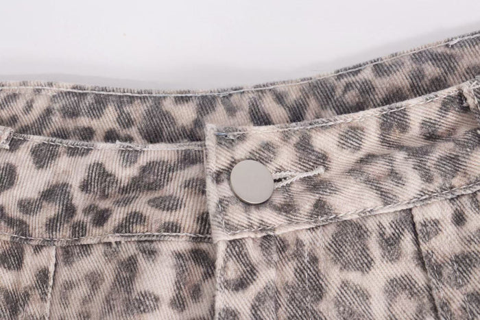 Close-up of leopard print denim waistband and snap button detail