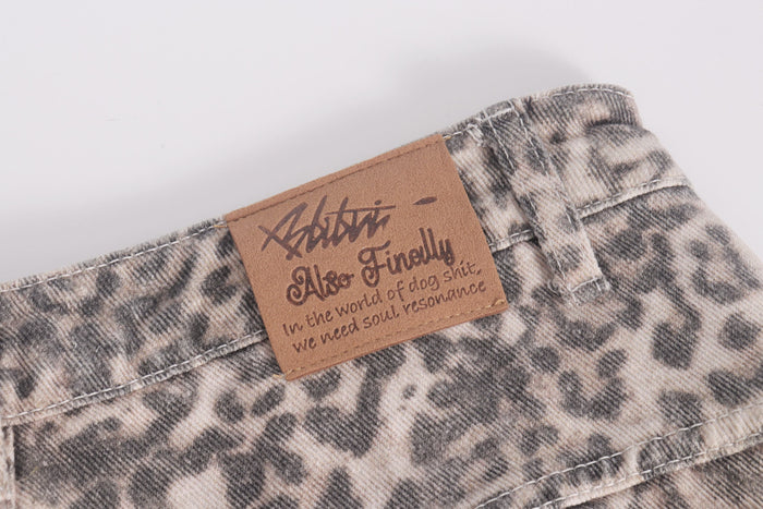 Close-up of brown logo patch on leopard print denim waistband