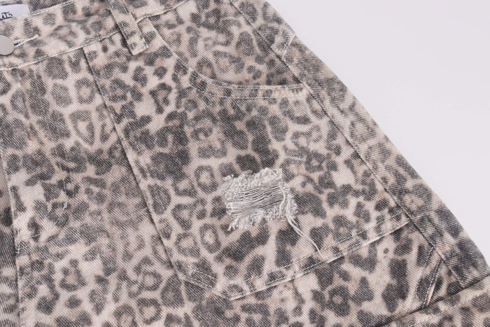 Close-up of back pocket on leopard print cargo jeans with distressed patch