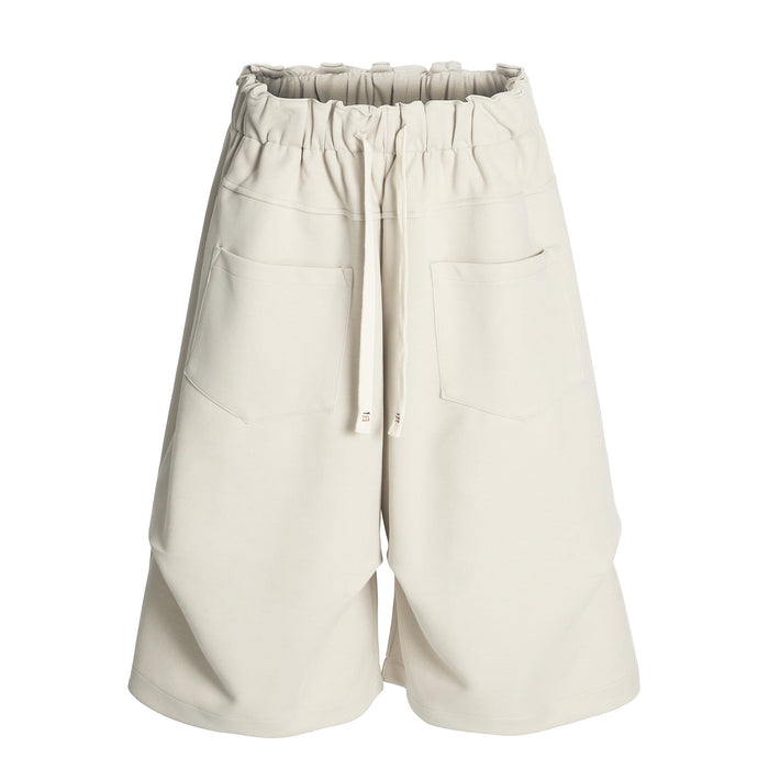 Cream wide-leg shorts front view with elastic waist, drawstring, and large patch pockets