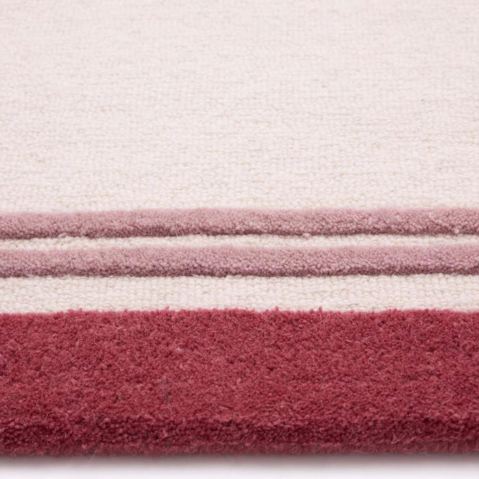 Close-up of a textured fabric with horizontal stripes in pink, white, and red.