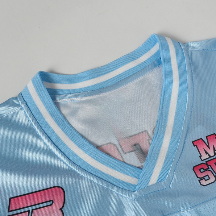 Close-up of a baby blue Y2K football jersey with white trim, pink lettering, and mesh streetwear texture